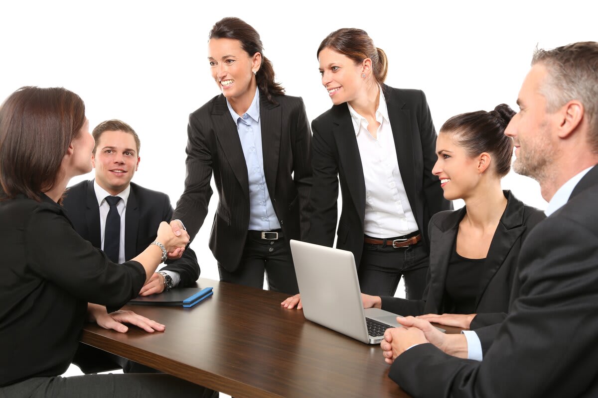 Software development team discussing a project around a laptop